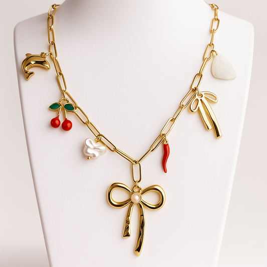 Gold necklace with various charms on a white background