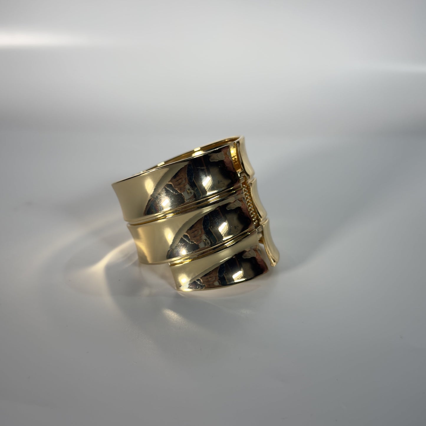 Gold ring on a reflective gray surface