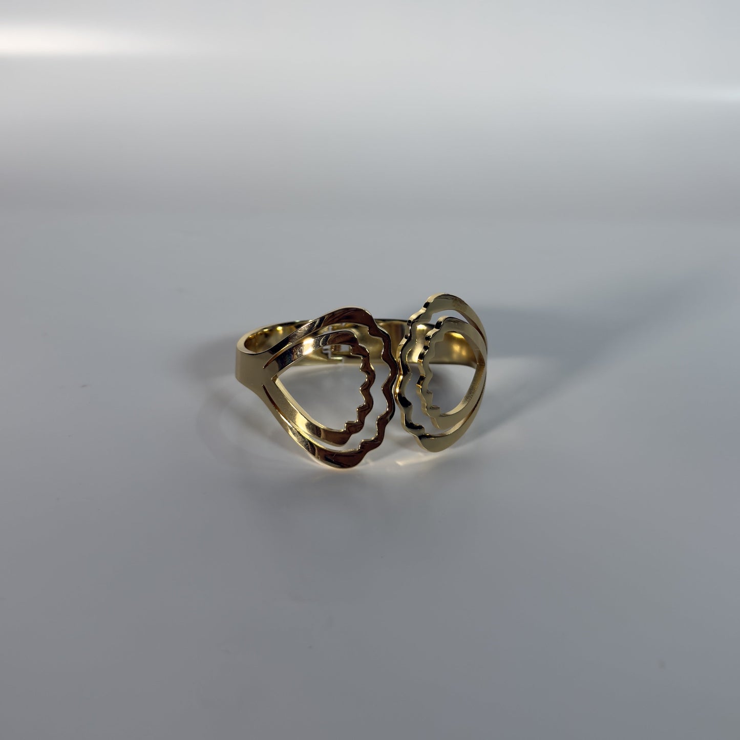 Gold ring with a heart design on a white background
