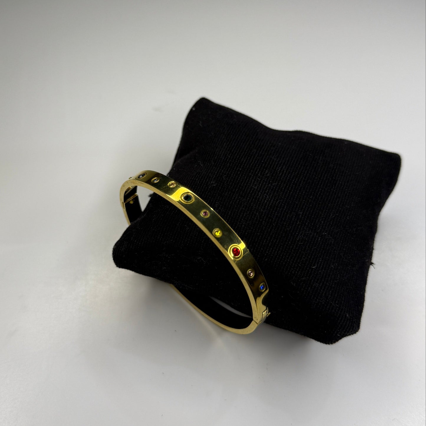 Gold ring on a black cushion against a white background