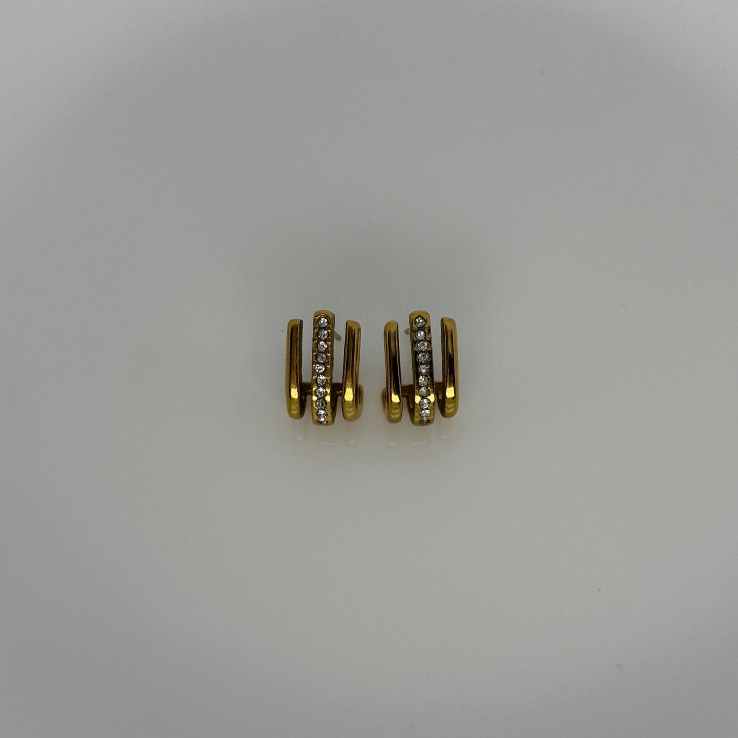 Three gold connectors on a white ceramic plate