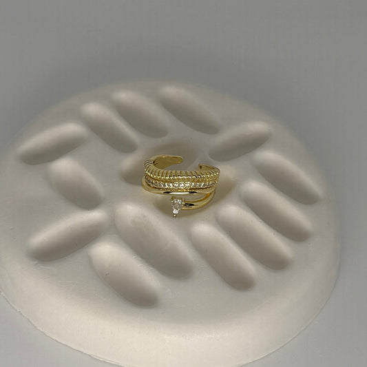 Two gold rings on a textured white surface with a gray background