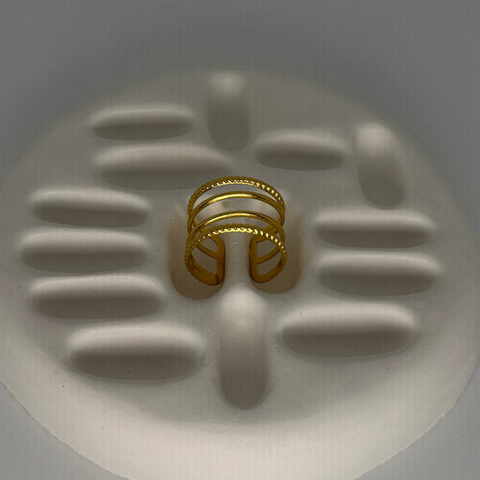 Gold ring on a textured white surface with a gray background