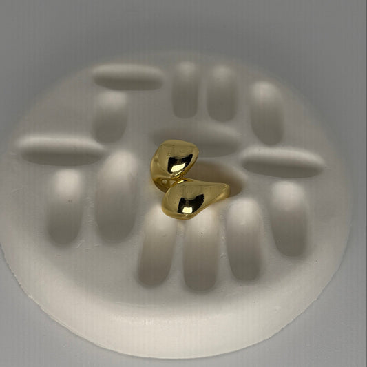 Gold ring on a white stone with 'W' engraving