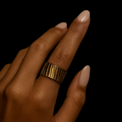 Gold ring on a brown-skinned hand against a white background