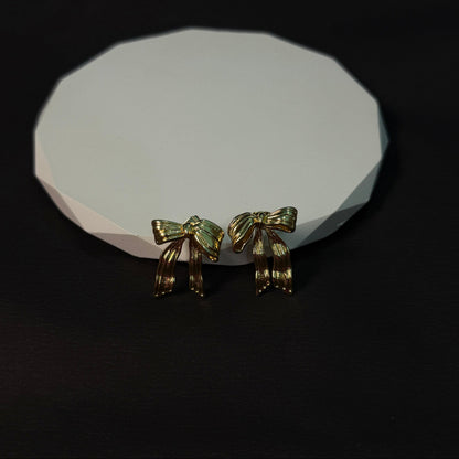 Two gold horse figurines on a white stone surface with a black background