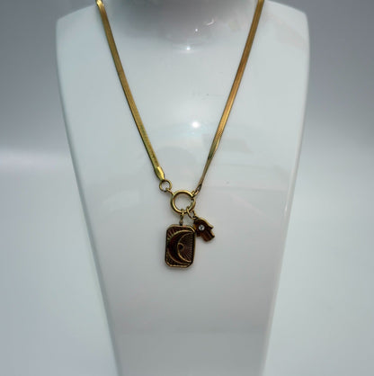 Gold necklace with a pendant on a white mannequin bust