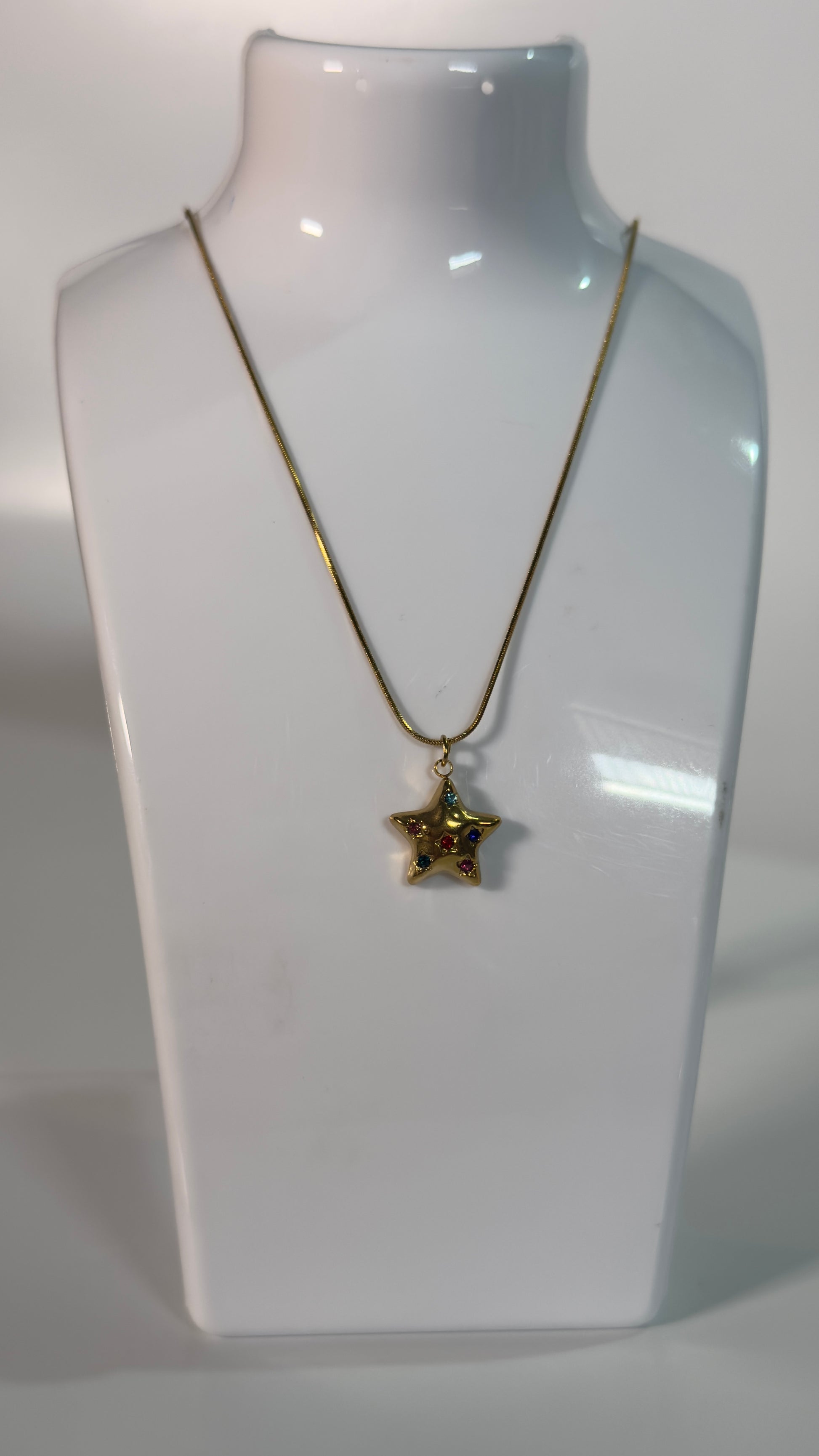 Necklace with a star-shaped pendant on a white mannequin bust