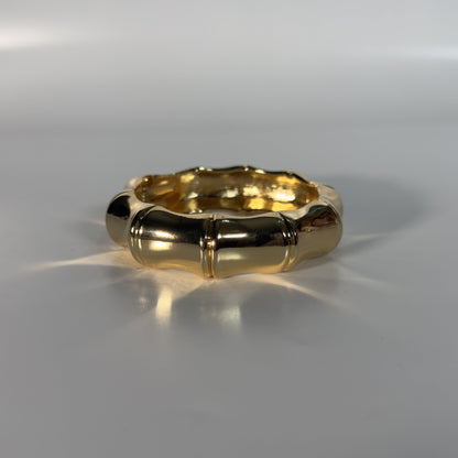 Gold ring on a reflective gray surface
