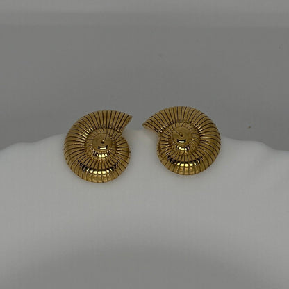 Pair of gold earrings on a white mannequin bust against a gray background