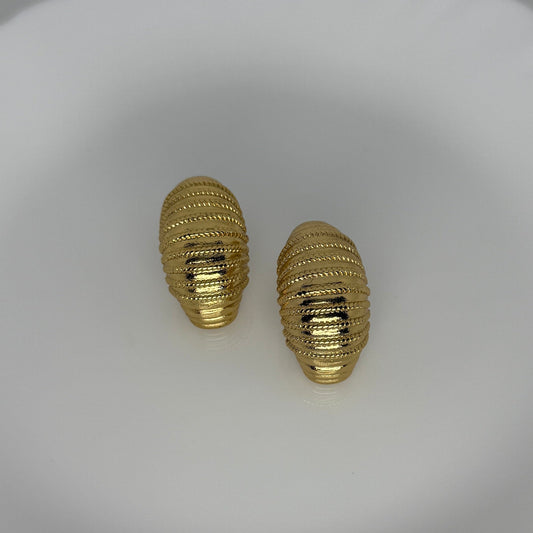 Pair of gold textured earrings on a white background