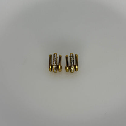 Three gold connectors on a white ceramic plate