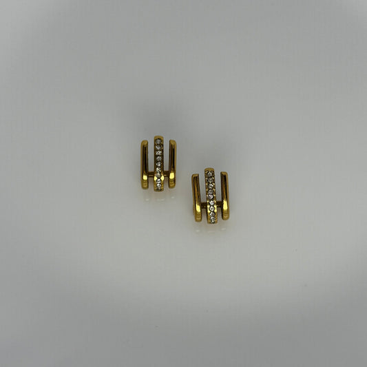 Gold hoop earrings with small diamonds on a light gray background